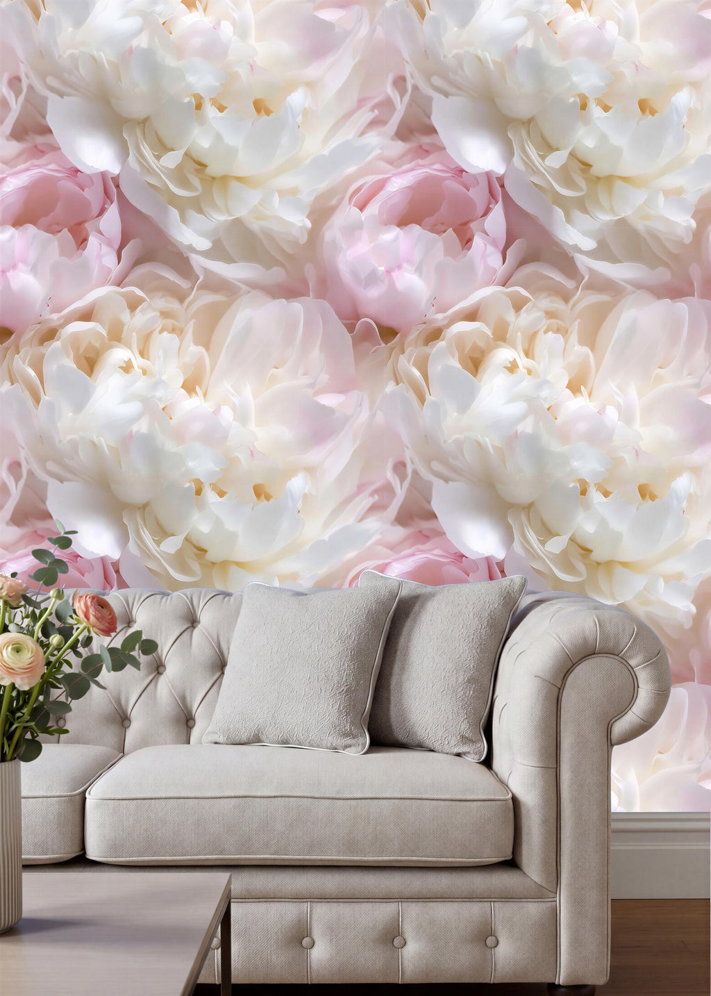 a large floral wallpaper with white and pink flowers, creating a beautiful and elegant backdrop for a beige sofa with two gray pillows.