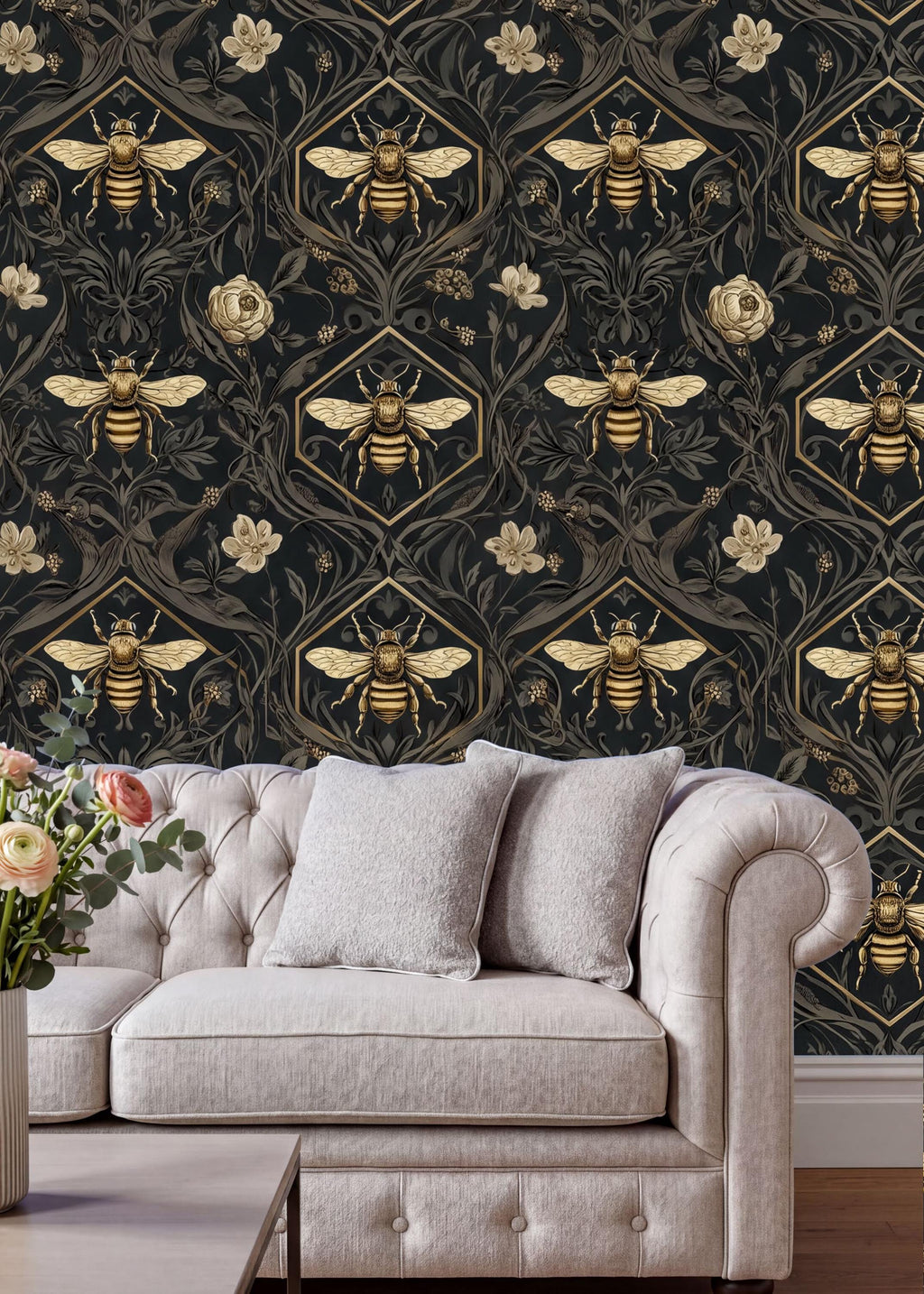 a living room with a white tufted sofa and a coffee table. The sofa is positioned against a wall with a repeating pattern of bees and flowers in gold and black. The wall also has a vase of flowers and a potted plant, adding a touch of nature to the room.