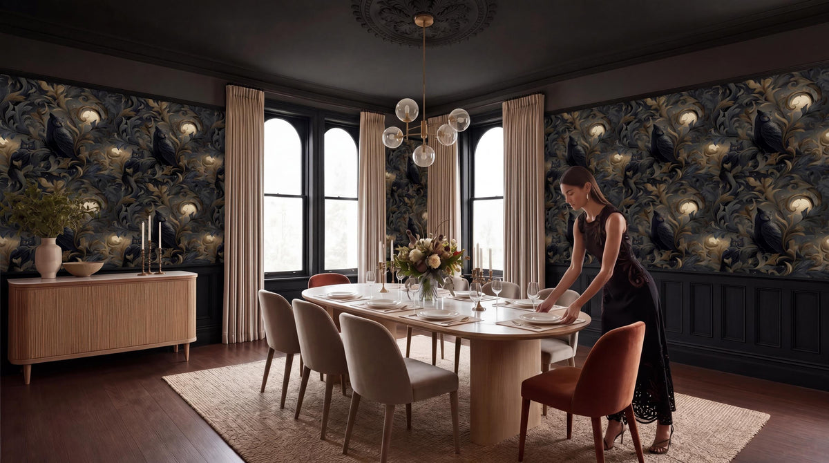 A woman in a black dress is setting the table in a dining room with a large chandelier overhead, a wooden table with white plates, and a vase of flowers.