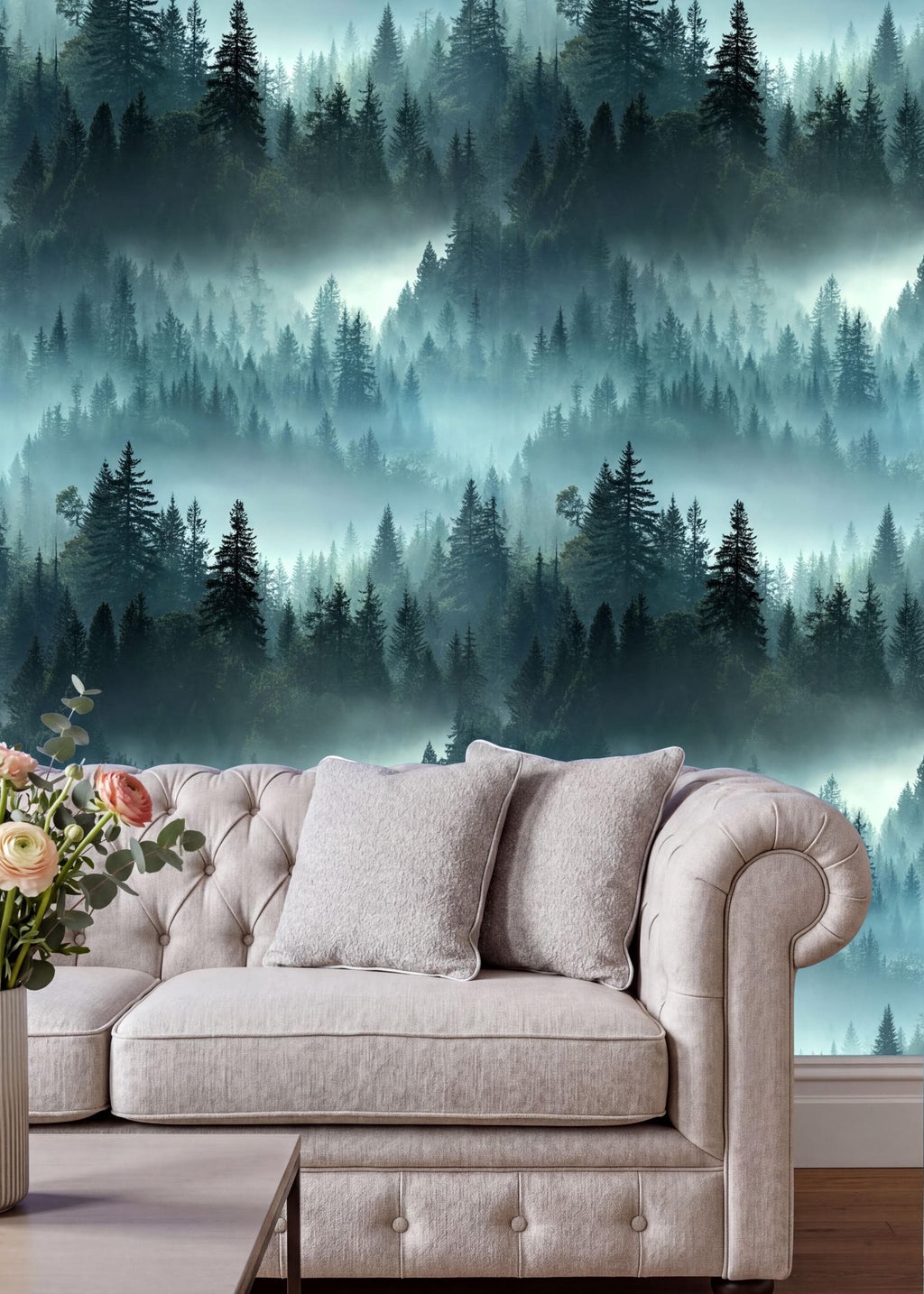 a cozy living room with a plush white sofa adorned with two matching pillows. The sofa is positioned against a wall that showcases a captivating forest scene, with a dense collection of trees and a misty atmosphere. The room is further decorated with a vase of flowers on a coffee table, adding a touch of natural beauty to the space.