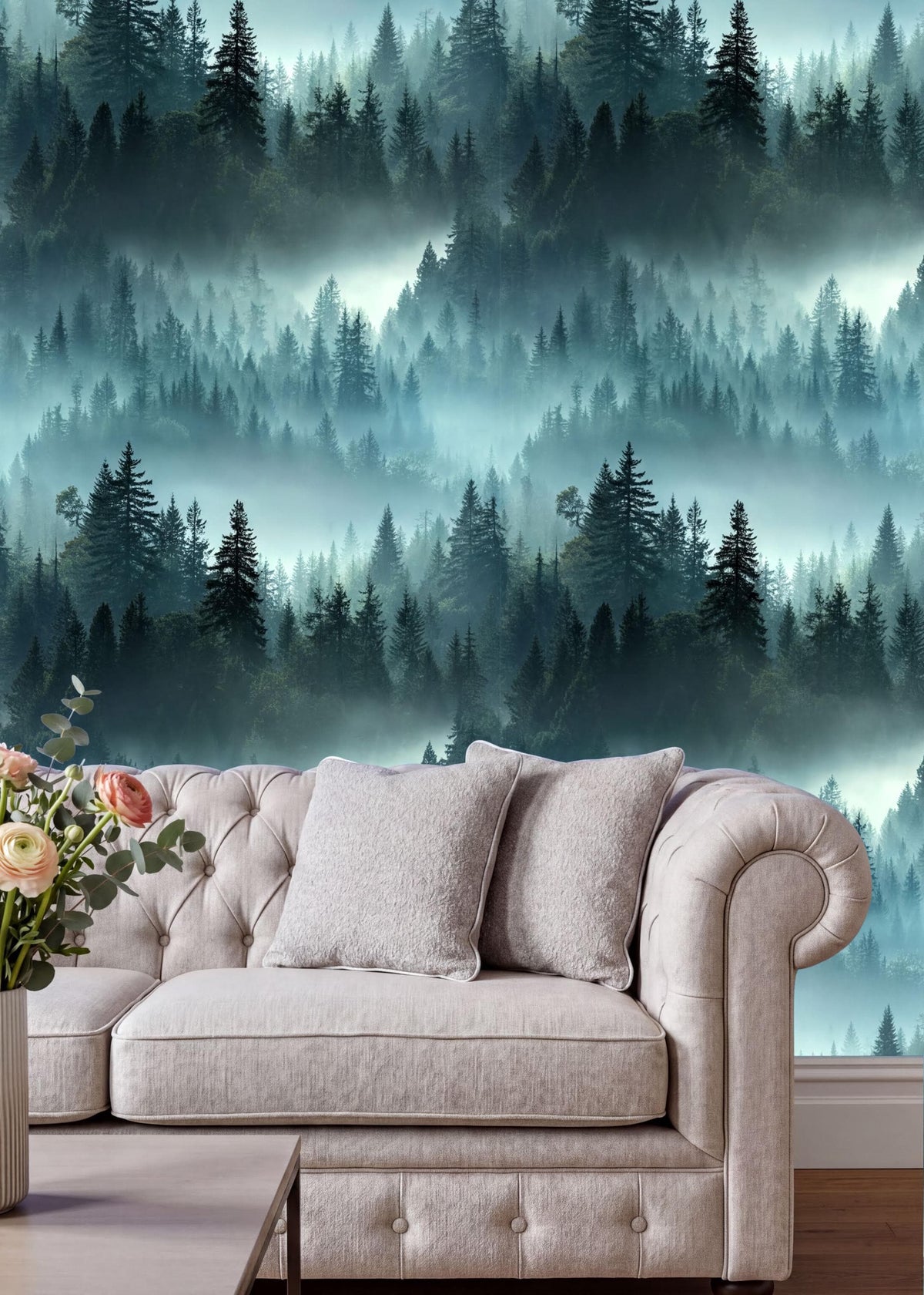 a cozy living room with a plush white sofa adorned with two matching pillows. The sofa is positioned against a wall that showcases a captivating forest scene, with a dense collection of trees and a misty atmosphere. The room is further decorated with a vase of flowers on a coffee table, adding a touch of natural beauty to the space.