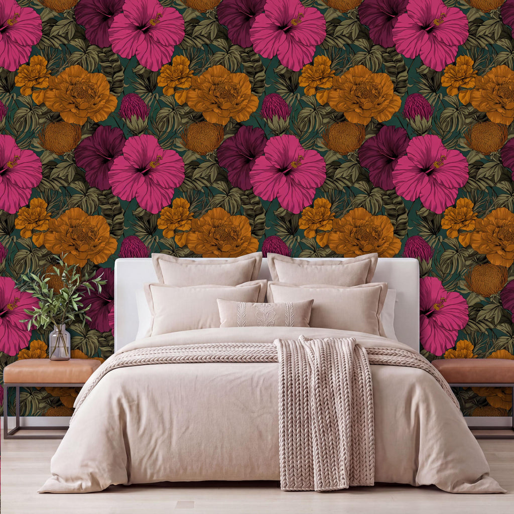 a bedroom with a large floral wallpaper behind the bed. The bed is dressed in a beige comforter and has several pillows. There is a wooden nightstand next to the bed, and a vase of flowers is placed on it.
