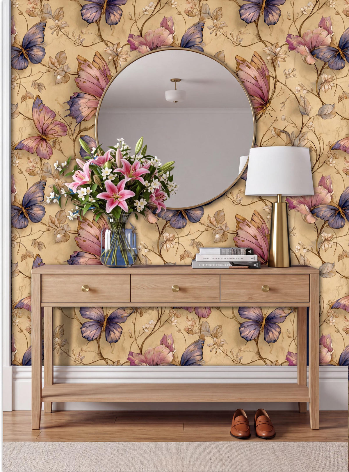 a wooden console table with a round mirror above it, set against a wall with a floral wallpaper. The table has a vase of flowers and a lamp on it, creating a cozy and inviting atmosphere.