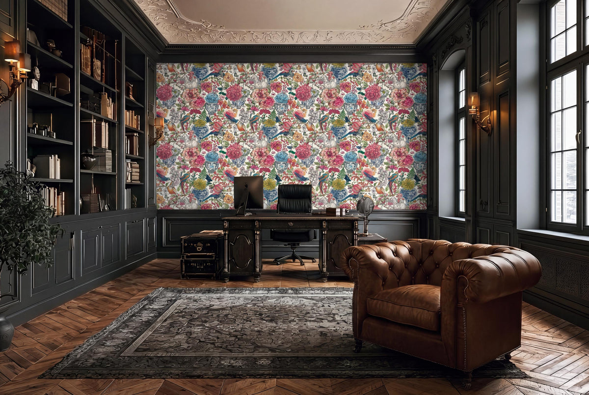 a luxurious and elegant living room with a large floral wallpaper covering the wall behind a desk and chair. The room has dark wood paneling, a large window, and a plush leather chair.