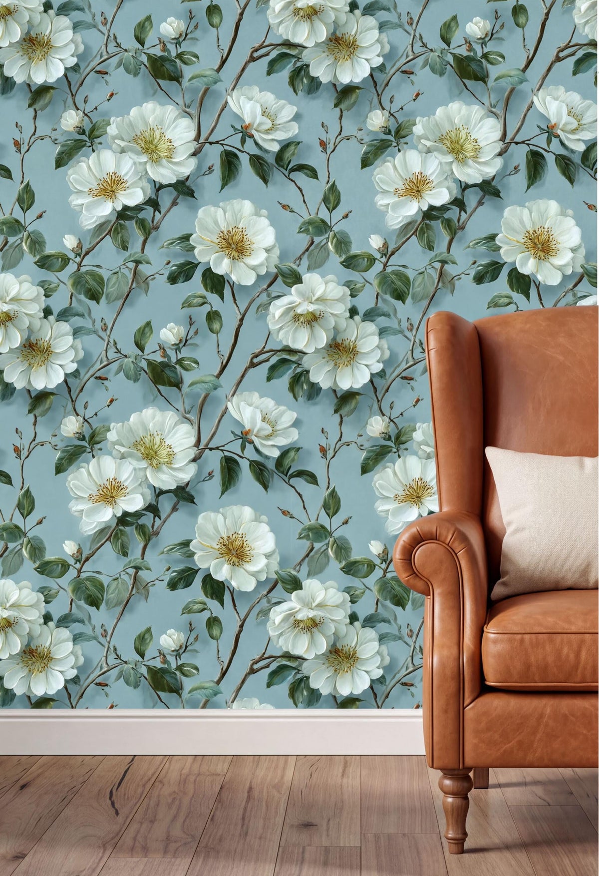 a wallpapered wall with a floral pattern of white flowers and green leaves, and a brown leather armchair with a white pillow in the foreground.