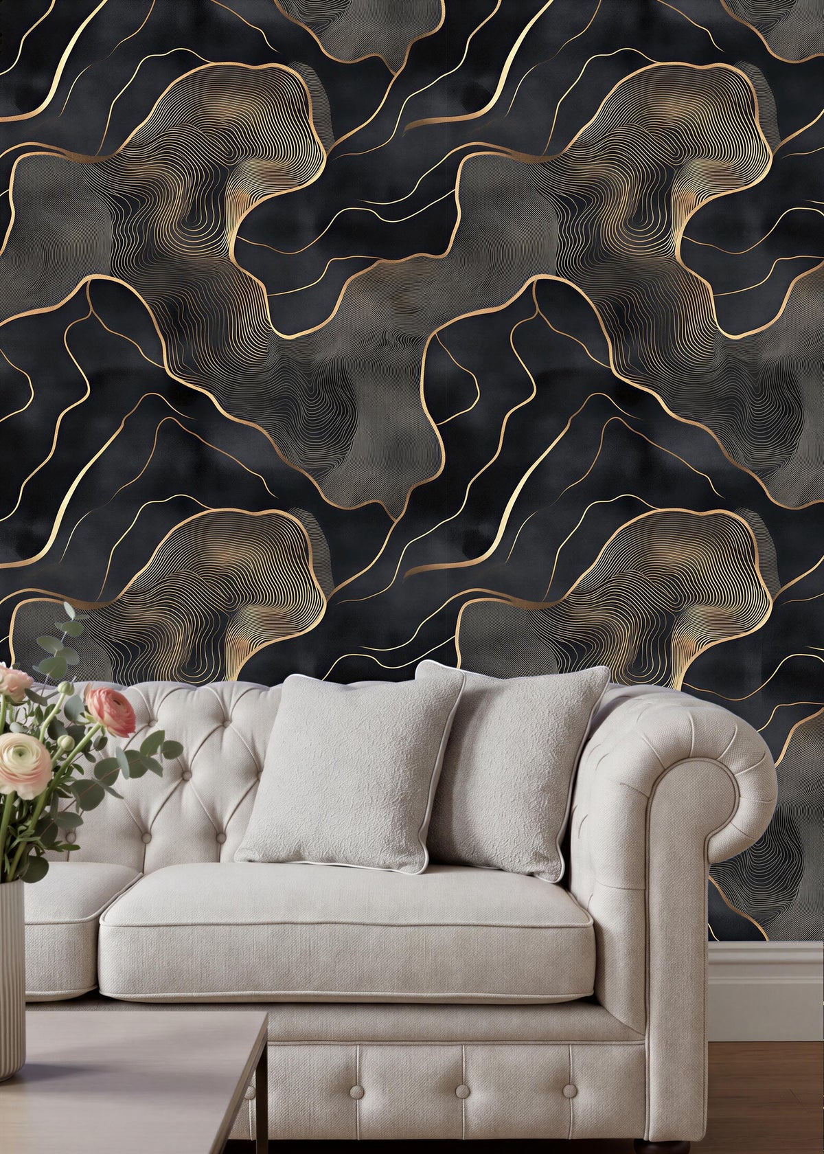 a luxurious living room with a white tufted sofa and a wooden coffee table. The sofa is positioned against a wall with a striking black and gold abstract wallpaper design. The room has a modern and elegant aesthetic, with the white sofa and wooden coffee table complementing the overall design.