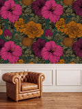 a brown leather armchair positioned in front of a vibrant floral wallpaper with a mix of pink, orange, and green hues.