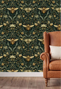 a wallpapered wall with a repeating pattern of bees and flowers in shades of green and gold. In the foreground, there is a brown leather armchair with a white pillow on it.
