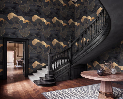 a grand staircase with a black railing and ornate wooden steps, leading up to a round wooden table with a black vase on top. The walls are covered in a dark, abstract wallpaper with gold accents, creating a striking and luxurious atmosphere.