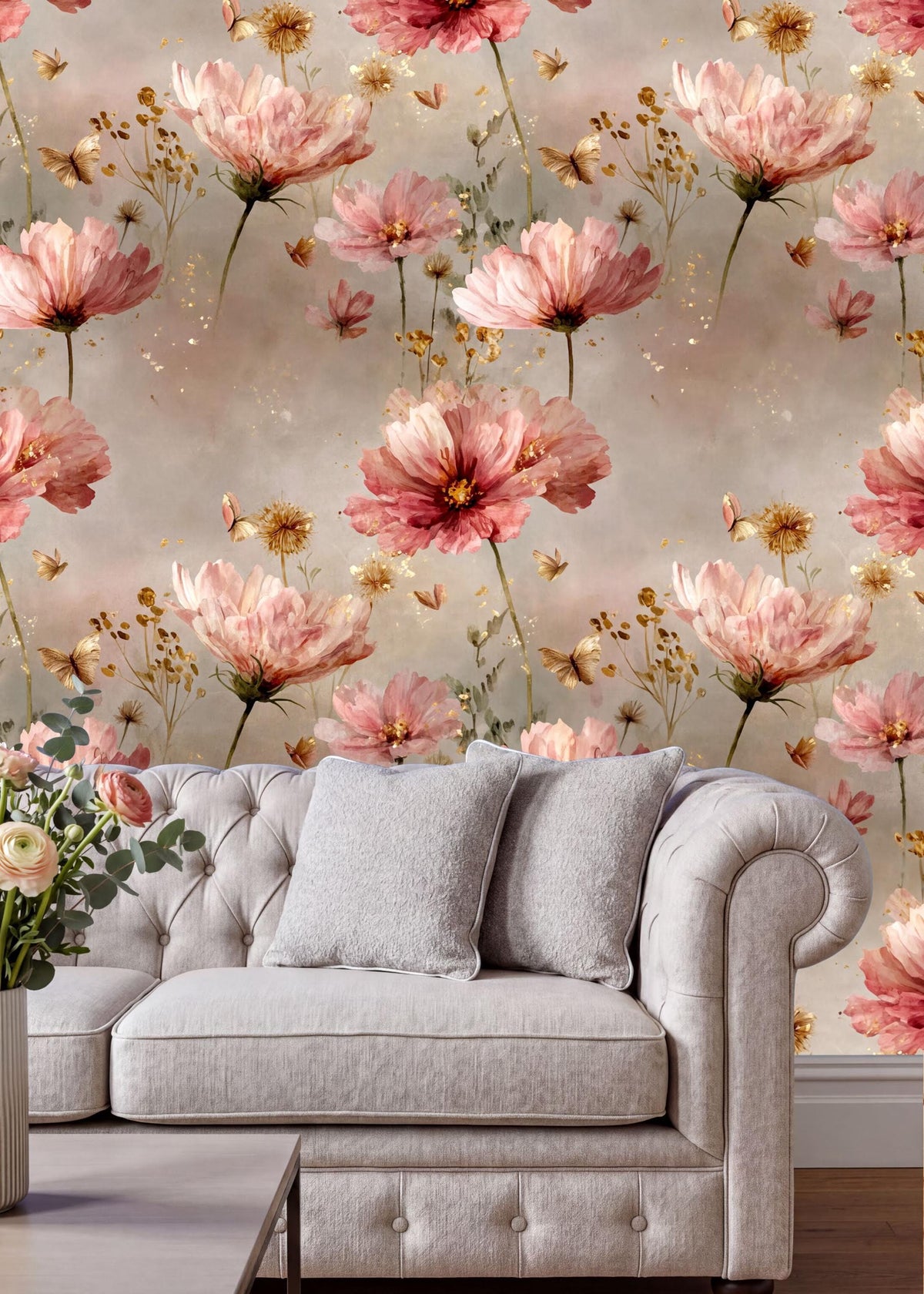 a cozy living room with a white tufted sofa adorned with two gray pillows. The sofa is positioned against a wall covered in a floral wallpaper, which is predominantly pink and white in color. The floral wallpaper adds a touch of elegance and warmth to the room, creating a welcoming atmosphere.