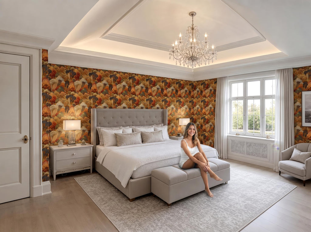 A woman sits on a bench in a luxurious bedroom with a large bed, a chandelier, and a patterned wallpaper.