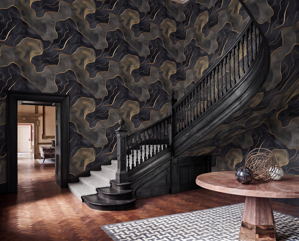 a grand staircase with a black railing and ornate wooden steps, leading up to a round wooden table with a metal sculpture on top. The walls are covered in a dark, abstract wallpaper with a gold and black pattern. The room has a high ceiling and a wooden floor, creating a sense of elegance and sophistication.