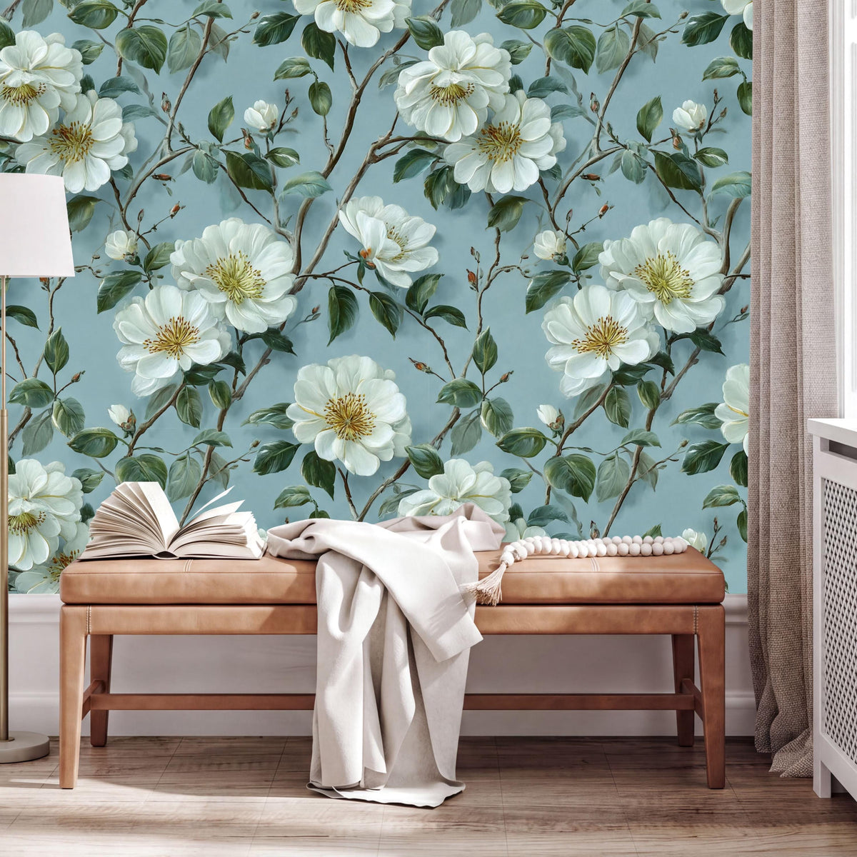 a wallpapered wall with a floral design of white flowers and green leaves, creating a serene and natural atmosphere. In the foreground, there is a wooden bench with an open book and a white blanket draped over it.
