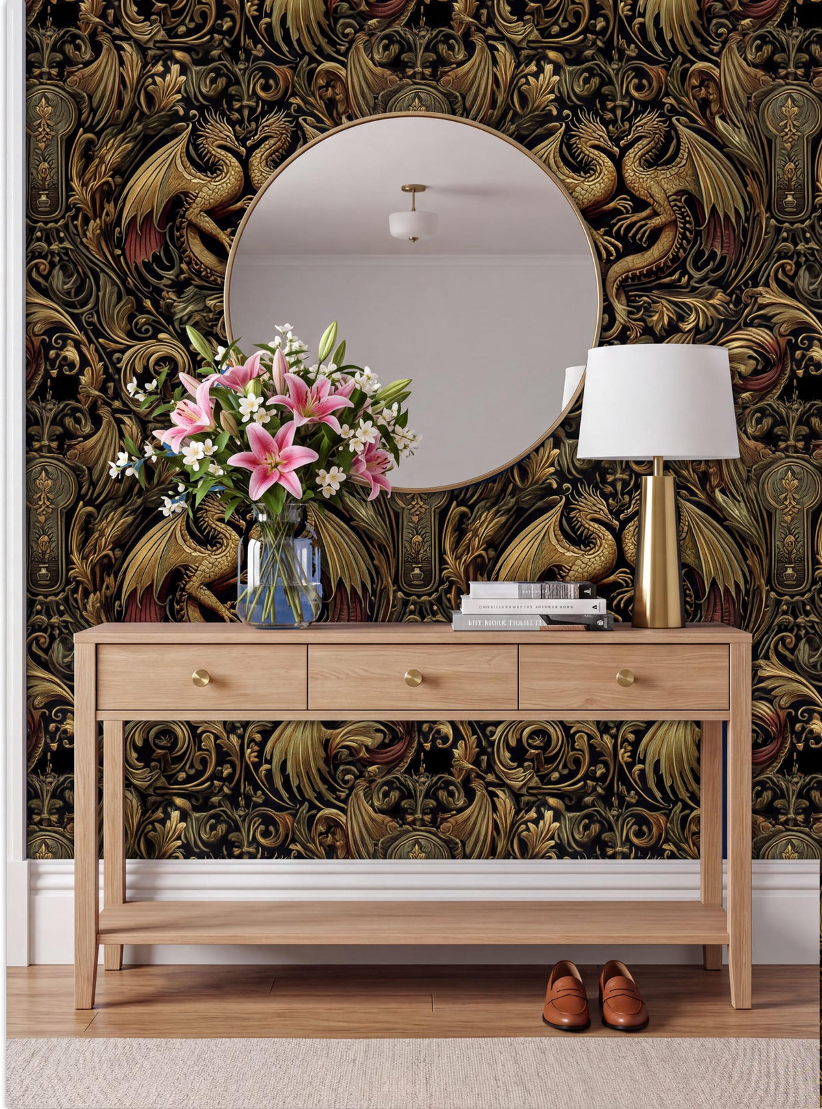 a wooden console table with a round mirror above it, a vase of pink lilies, and a lamp on the table. The wall behind the table has a gold and black dragon wallpaper.