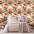 a bedroom with a large floral wallpaper behind the bed. The bed is covered in a beige comforter and has several pillows. There is a wooden nightstand on the left side of the bed, and a vase of flowers is placed on it.