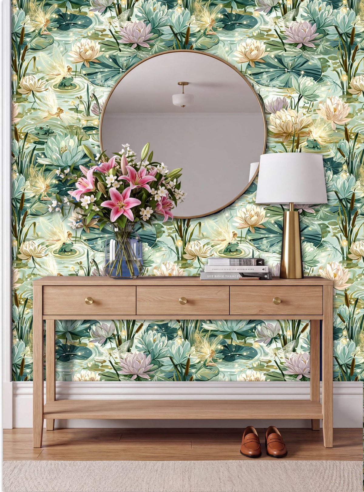 a wooden console table with a round mirror above it, set against a wall with a vibrant, colorful wallpaper pattern of water lilies and other aquatic plants. The table also holds a vase of pink flowers and a lamp, creating a cozy and inviting atmosphere.