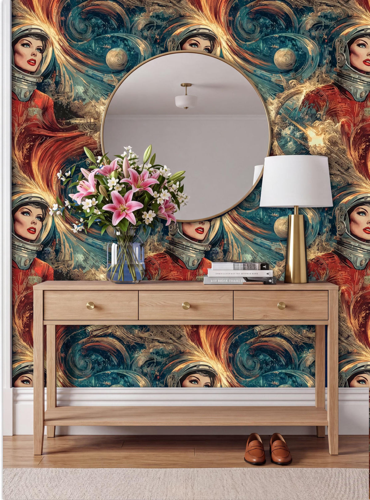a wooden console table with a round mirror above it, a vase of flowers, and a lamp on top. The wall behind the table has a vibrant, swirling wallpaper with a woman's face and other abstract designs.