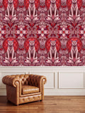 a brown leather armchair positioned in front of a wall with a repeating pattern of pink and red floral designs.