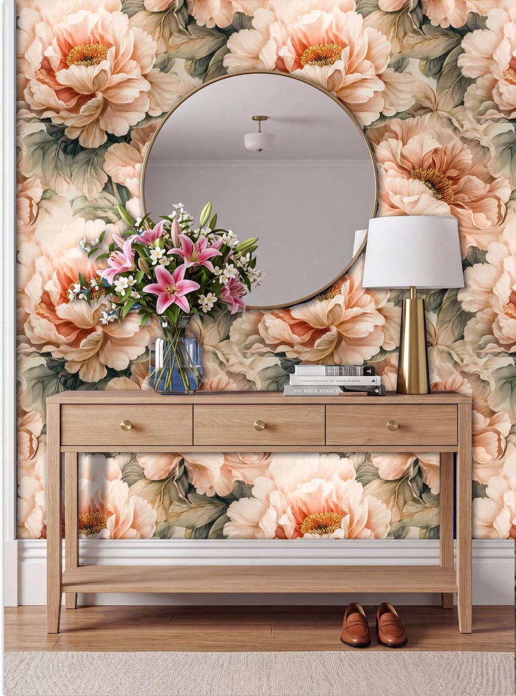 a wooden console table with a round mirror above it, set against a wall with a floral wallpaper. The table has a vase of flowers and a lamp on it, creating a cozy and inviting atmosphere.