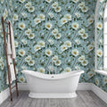 a bathroom with a white freestanding bathtub, a wooden ladder, and a wall covered in a floral wallpaper with white flowers and green leaves.