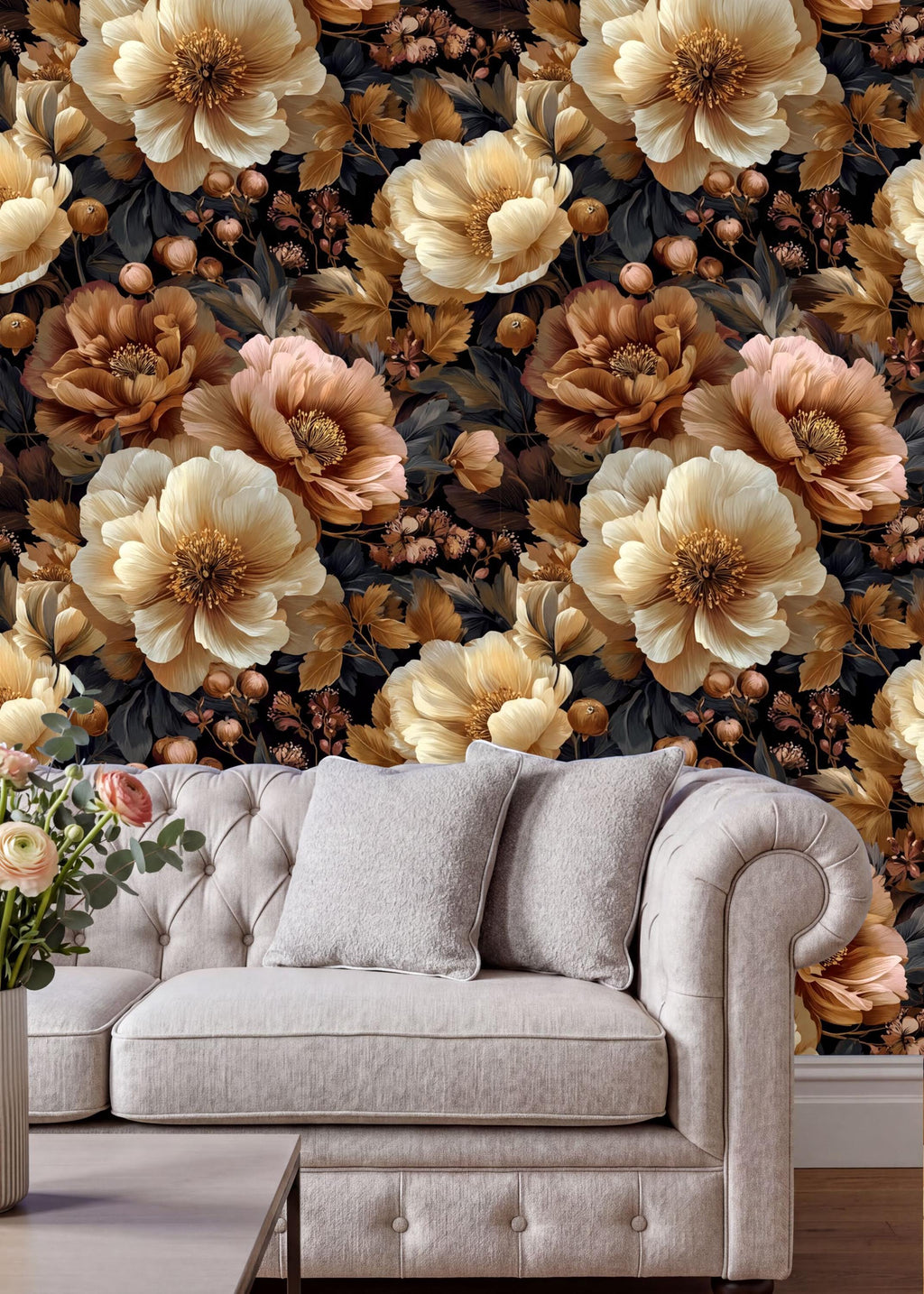 a large floral wallpaper with a mix of white, gold, and brown flowers and leaves, creating a warm and inviting atmosphere. In the foreground, there is a white tufted sofa with two gray pillows, and a vase of flowers on the coffee table.