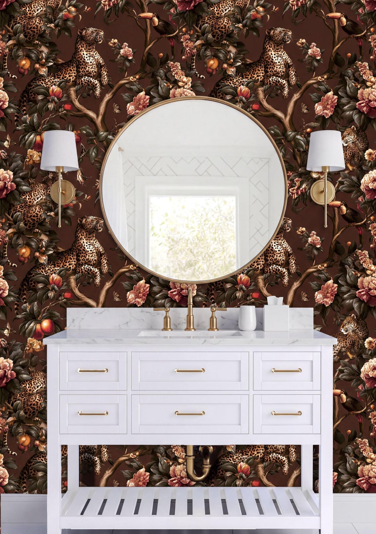 a bathroom vanity with a white countertop and drawers, set against a wall with a large round mirror and two wall sconces. The wall behind the vanity is covered in a vibrant, floral wallpaper pattern in shades of brown and gold.