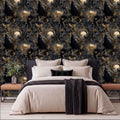 a bedroom with a large bed, dark and light brown bedding, and a black and white throw blanket. The bed is positioned against a wall with a repeating pattern of owls and moon motifs in shades of black and gold.