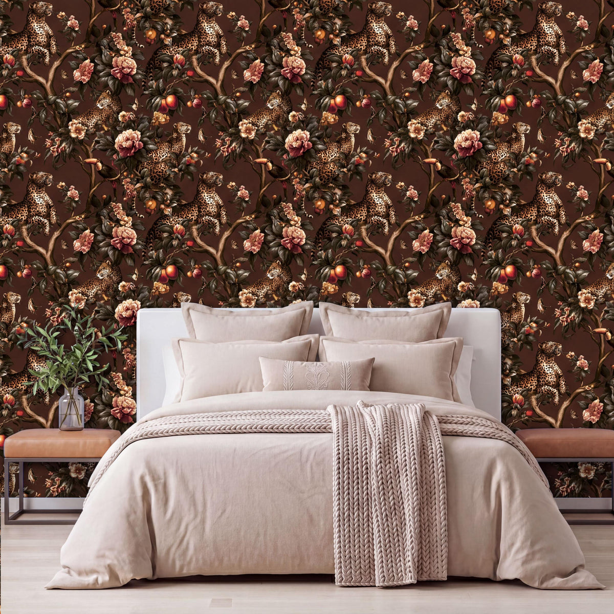 a bedroom with a large bed, a white headboard, and a floral wallpaper behind it. The bed is dressed in a beige comforter and has several pillows. There is also a wooden nightstand next to the bed, and a potted plant is visible on the left side of the room.