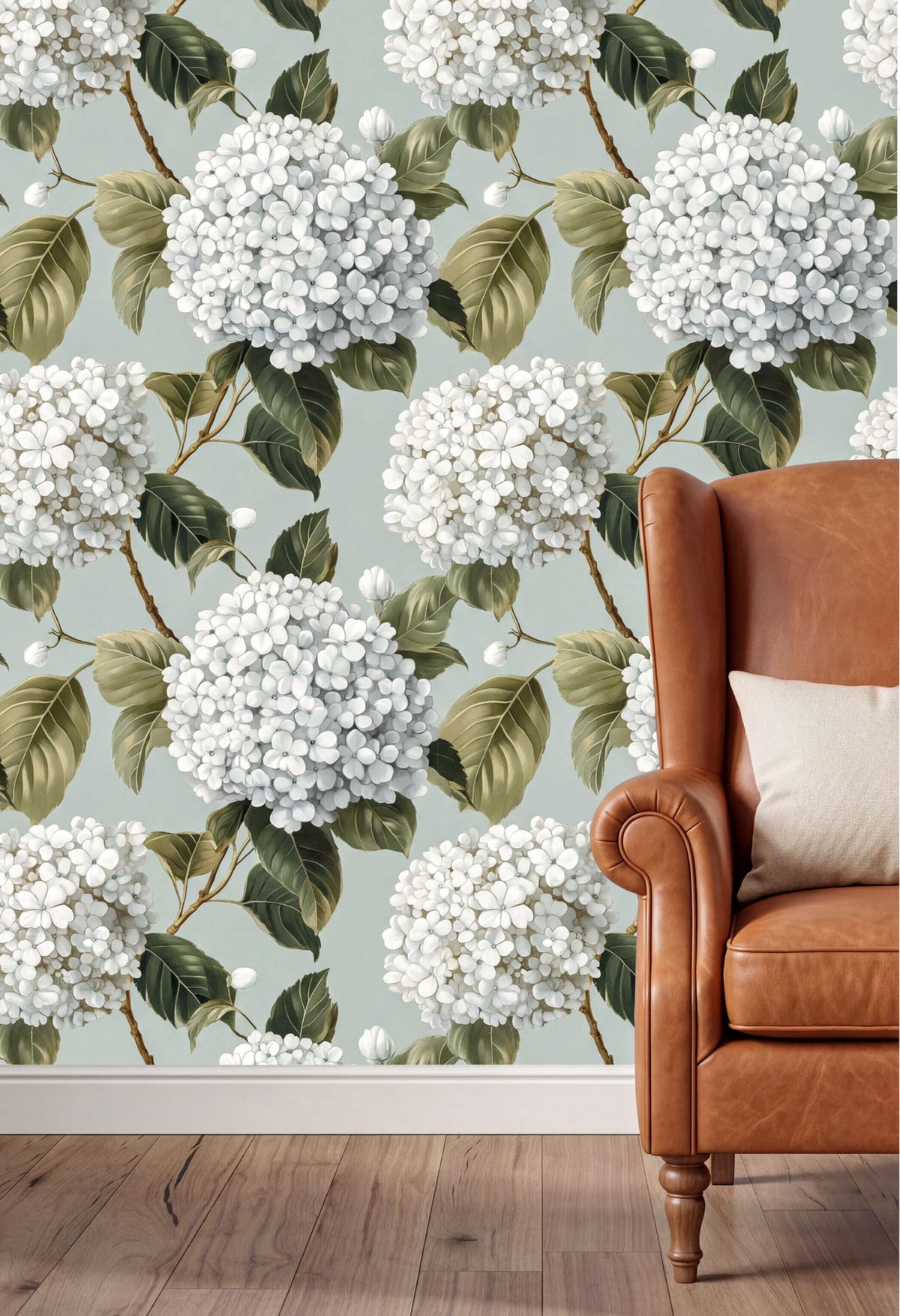 a wallpapered wall with a floral pattern of white hydrangeas and green leaves, creating a serene and natural atmosphere. In the foreground, there is a brown leather armchair with a white pillow, adding a touch of elegance and comfort to the scene.