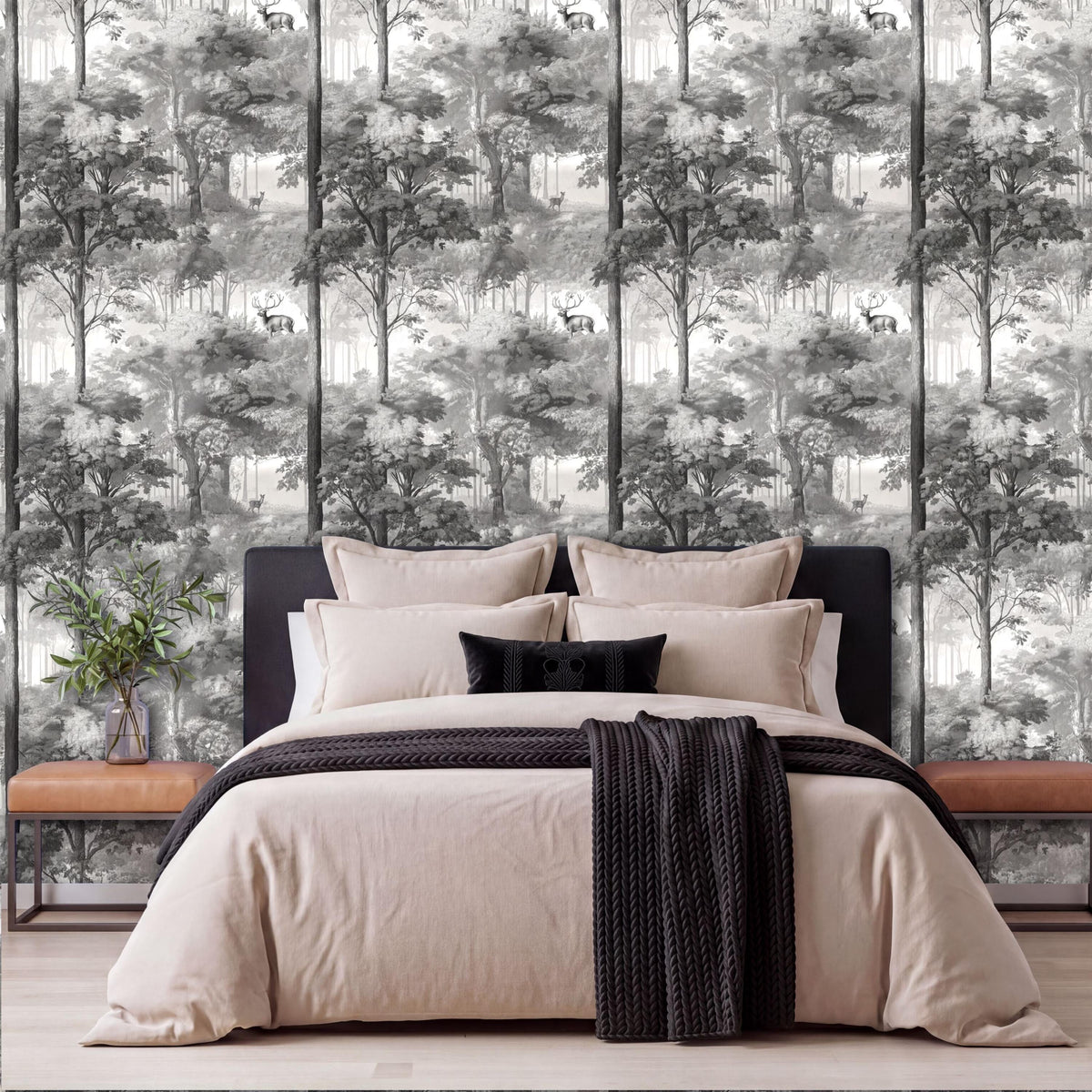a bedroom with a large bed, dark headboard, and a forest-themed wallpaper behind it. The bed is dressed in a beige comforter and black throw blanket.