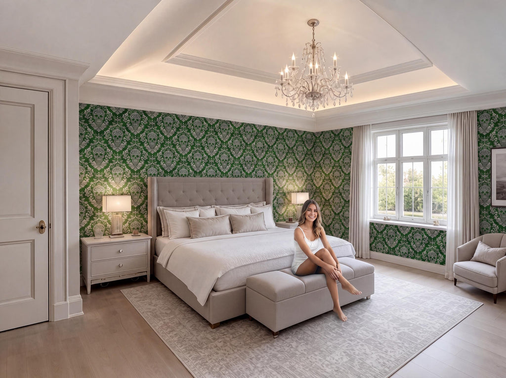 A woman sits on a bench in a luxurious bedroom with a large bed, a chandelier, and a patterned wallpaper.