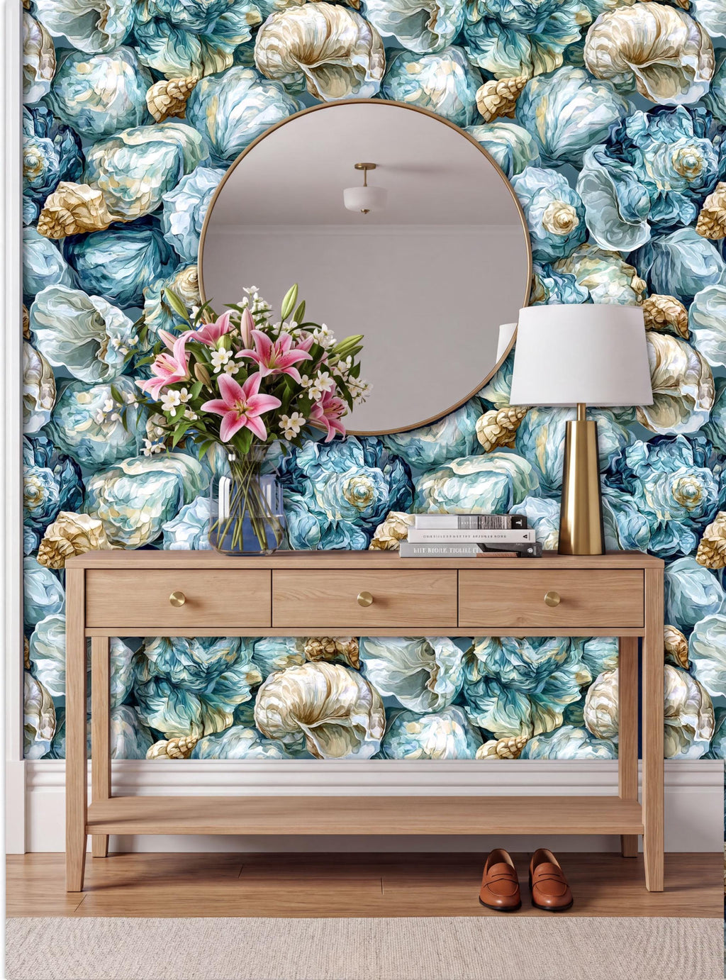 a wooden console table with a round mirror above it, set against a wall with a vibrant floral wallpaper. The table has a vase of pink flowers and a lamp on it, creating a cozy and inviting atmosphere.