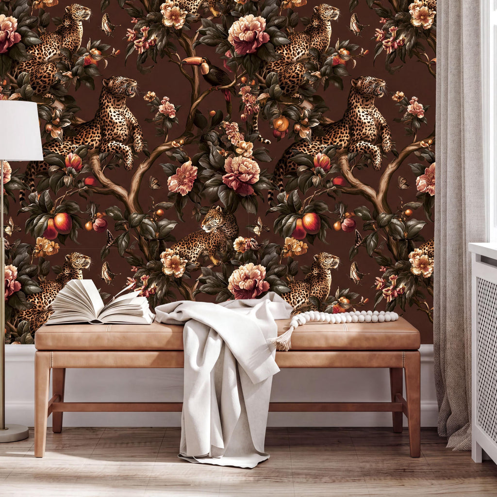 a large wallpapered wall with a floral design, including a tree with leopards and various flowers and fruits. In front of the wall, there is a wooden bench with an open book and a white blanket draped over it.