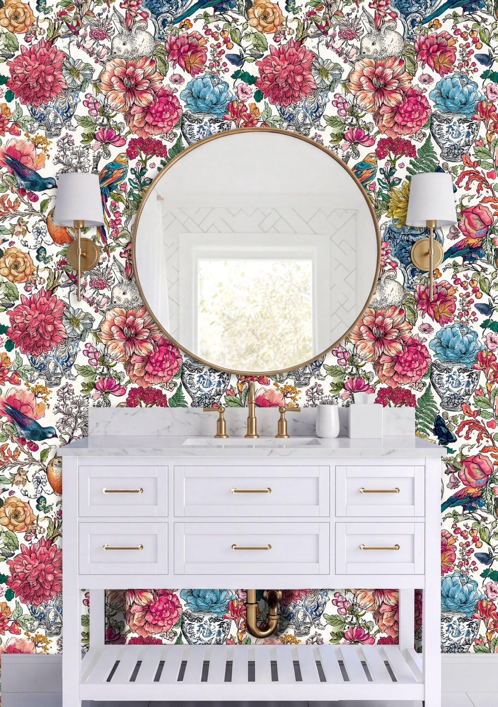 a bathroom vanity with a white countertop and drawers, set against a vibrant floral wallpaper. Above the vanity is a round mirror with gold fixtures, and two white sconces flank the mirror.