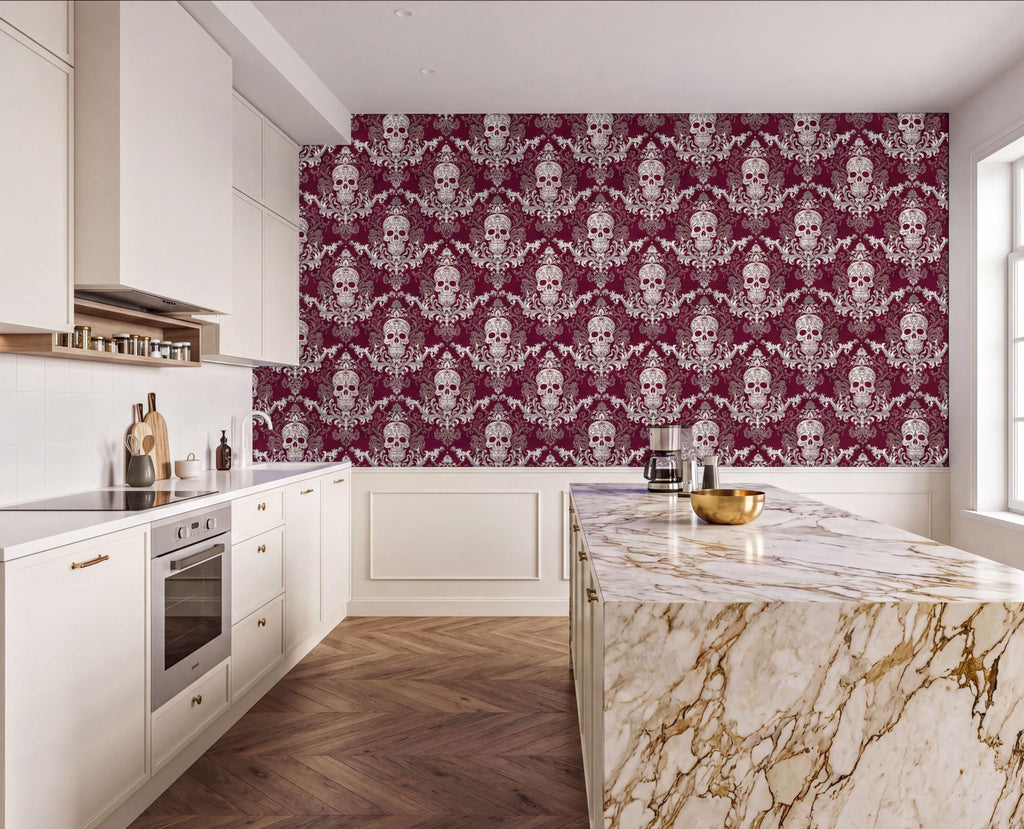 a modern kitchen with a large, marble-topped island and a white countertop. The walls are covered in a repeating pattern of skulls and floral designs in burgundy and white. The kitchen features white cabinets and a stainless steel oven.