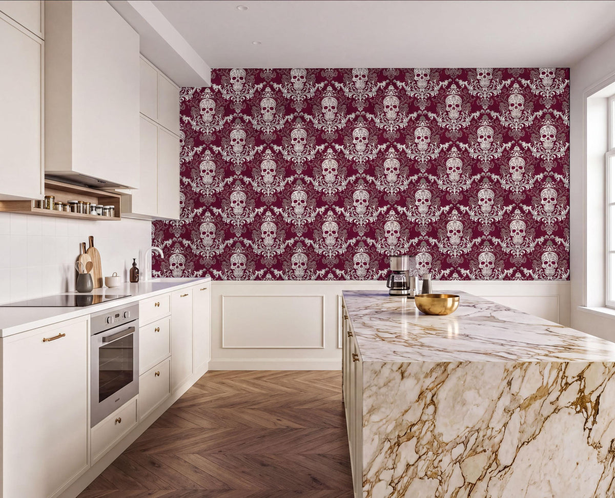 a modern kitchen with a large, marble-topped island and a white countertop. The walls are covered in a repeating pattern of skulls and floral designs in burgundy and white. The kitchen features white cabinets and a stainless steel oven.